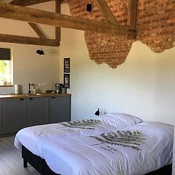 Gemuetliches Schlafzimmer des Ferienhauses in Axel mit Holzbalken und Landhausstil in Zeeland.