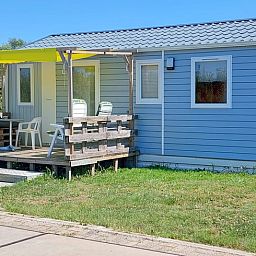 Vakantiehuisje in Hengstdijk, Zeeuws-Vlaanderen met zonnige veranda en groene omgeving, ideaal voor ontspannen verblijf in Zeeland.