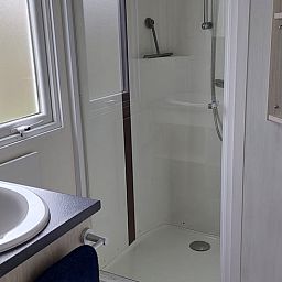 Moderne badkamer in Vakantiehuisje in Hengstdijk, Zeeuws-Vlaanderen, Zeeland met douche en wastafel voor comfortabel verblijf.