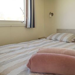 Gezellige slaapkamer in Vakantiehuisje in Hengstdijk, Zeeuws-Vlaanderen, met comfortabel bed en rustgevend uitzicht op de natuur.