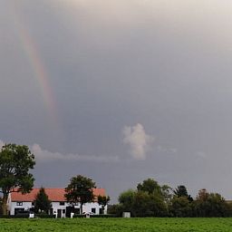 Prachtige regenboog boven Vakantiehuisje in IJzendijke, omgeven door natuur.