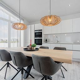 Eetkamer van Vakantiehuis Ruisweg 12, Wemeldinge, Zeeland, met stijlvolle eettafel en hanglampen, ideaal voor familiediners.