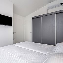 Elegante slaapkamer in Vakantiehuis Ruisweg 12, Wemeldinge, Zuid-Beveland, met tweepersoonsbed en moderne opbergruimte.