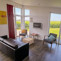 Helles Wohnzimmer im Ferienhaus Waterresort Oosterschelde Haus Nr. 51, mit Panoramablick auf die Natur in Sued-Beveland.