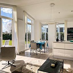 Lichte eetruimte in Vakantiehuis Waterresort Oosterschelde - huisnr. 56, Wemeldinge. Uitzicht op de tuin en veel natuurlijk licht.