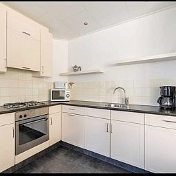 Modern kitchen in vacation home Scheldeoord 54, Baarland, Zeeland with oven, microwave and coffee maker. Perfect for a comfortable stay.