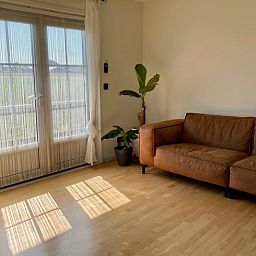 Gezellige woonkamer met leren bank in Vakantiehuis in Lewedorp, ideaal voor ontspanning in Zuid-Beveland, Zeeland.