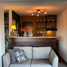 Gemuetlicher Innenbereich des Ferienhauses Cottage in Brandwijk, mit bequemem Sofa und stimmungsvoller Beleuchtung.