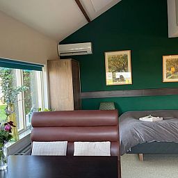 Schlafzimmer in Ferienhaus in Brandwijk, Alblasserwaard mit moderner Einrichtung und Gartenblick.