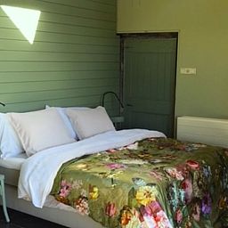 Gezellige slaapkamer in Huisje in Stolwijk, Zuid-Holland, met comfortabel bed en rustieke uitstraling.