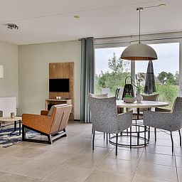 Gemtliches Wohnzimmer in einer Doppelhaushlfte in Ouddorp, Goeree-Overflakkee, Sdholland, mit moderner Einrichtung und Blick auf die Natur.