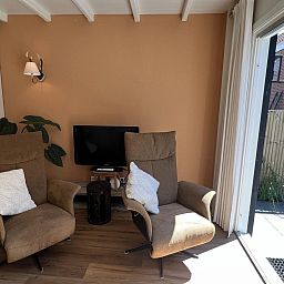 Knusse binnenruimte van VZ1114 Vakantieappartement in Ouddorp met comfortabele stoelen.