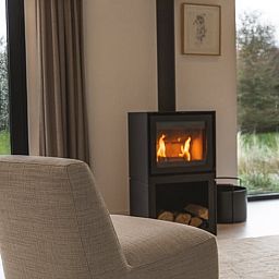 Gemuetliches Wohnzimmer mit Holzofen im Ferienhaus in Ouddorp, Suedholland, ideal zum Entspannen und Geniessen der Aussicht auf die Natur.