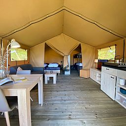 Innenbereich des Safarizeltes Zeeduin in Ouddorp, Goeree-Overflakkee. Gemuetliche Glamping-Lodge mit Holzboden und komfortabler Einrichtung.