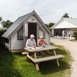 Gasten genieten van de rust op het terras van Kampeerhut 't Gorsje, gelegen in het mooie Ouddorp.