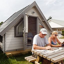 Vakantiegangers ontspannen bij Kampeerhut 't Gorsje, een idyllische plek in het hart van Goeree-Overflakkee.