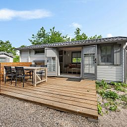 Veranda des Kampeerchalet de Zeekoet in Ouddorp, ideal fuer Mahlzeiten im Freien auf Goeree-Overflakkee, Suedholland.