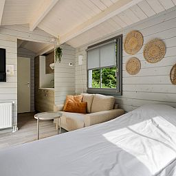 Gemuetliches Schlafzimmer im Kampeerchalet de Zeekoet in Ouddorp mit natuerlichen Elementen und bequemem Bett.