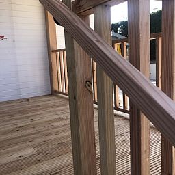 Detail der Holzveranda des Chalets Thuiz in Ouddorp, Suedholland, mit einer warmen, natuerlichen Ausstrahlung.