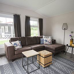 Gemuetliches Wohnzimmer des Chalet Ouddorp in Ouddorp, Goeree-Overflakkee. Komfortables Ferienhaus mit grosser Sitzecke in Suedholland.
