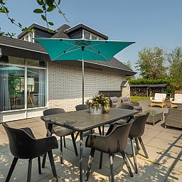 Buitenzitje met parasol bij Vakantiewoning De Toekomst 107 'Siesta' in Ouddorp, ideaal voor zomerse dagen.