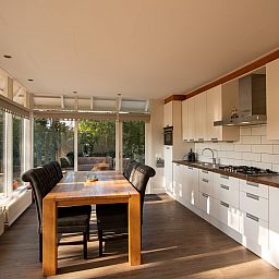 Helle Kueche und Essbereich im Ferienhaus De Toekomst 126 Beachgarden in Ouddorp, Suedholland.