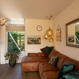 Gemuetliches Wohnzimmer im Ferienhaus De Toekomst 126 Beachgarden in Ouddorp mit stilvoller Einrichtung.