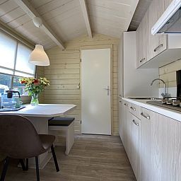 Cozy kitchen and dining area in Camping Chalet the Albatros Plus, Ouddorp, South Holland. Perfect for a relaxing vacation on Goeree-Overflakkee.