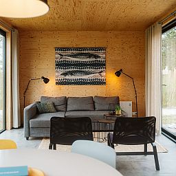Cozy living room of Duunroos vacation home in Ouddorp, with wooden interior and lots of light.