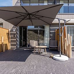 Elegant ingerichte zithoek in het 2-persoons appartement 2L, Ouddorp, met een moderne tv en stijlvolle decoratie.