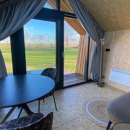 Innenansicht des Ferienhauses in Sommelsdijk mit Blick auf gruene Felder in Suedholland.