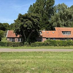 Gemuetliches Ferienhaus in Goedereede mit rotem Dach und gruener Umgebung in Suedholland.