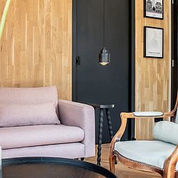 Gezellige zitruimte in Vakantiehuisje in Reeuwijk, Groene hart, Zuid-Holland, met stijlvolle houten muren en comfortabele fauteuils.