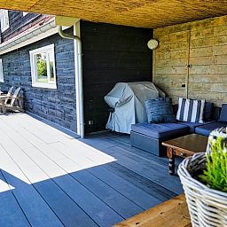 Geniet van de overdekte veranda bij Vakantiehuis in Gouderak, gelegen in het Groene Hart van Zuid-Holland, met comfortabele zithoek.