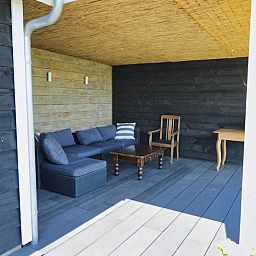 Ontspan op de knusse veranda van Vakantiehuis in Gouderak, gelegen in het Groene Hart van Zuid-Holland, met comfortabele zitplekken.
