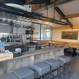 Moderne Kueche und Essbereich im Ferienhaus in Gouderak, Green Heart, Suedholland, mit gemuetlicher Sitzecke und Holzelementen.