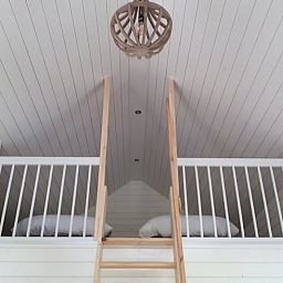 Cozy sleeping loft in Holiday home in Hazerswoude-Rijndijk, Green Heart, South Holland, with wooden interior and comfortable beds.