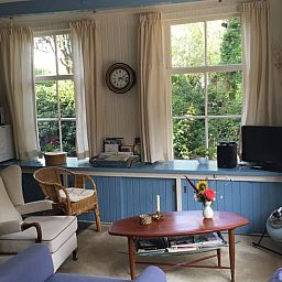 Gezellige woonkamer in Vakantiehuisje in Vlist, Groene Hart, Zuid-Holland met comfortabele stoelen en uitzicht op de tuin.