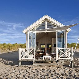 Geniessen Sie die HaagseStrandhuisjes 5 pers in Den Haag, ein charmantes Ferienhaus an der Nordseekueste mit einer einladenden Veranda.