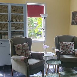 Comfortable sitting area in Holiday home in Oostvoorne, Voorne Putten, overlooking the garden.