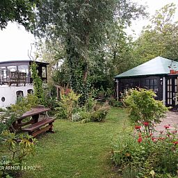 Relax in the green garden of vacation home ZH491 in Rotterdam, South Holland, with an idyllic terrace and natural surroundings.