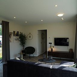 Modernes Wohnzimmer in einem freistehenden Haus in Dordrecht, Sdholland, mit grozgiger Sitzecke und Blick auf den Garten, ideal fr einen entspannten Aufenthalt.