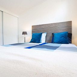 Slaapkamer in Rialto 5 personen vakantiehuis in Nieuwerkerk aan den IJssel met comfortabel tweepersoonsbed en sfeervolle verlichting.