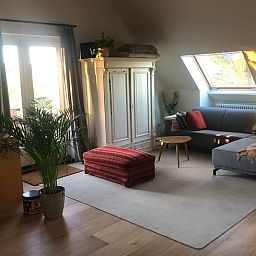 Gezellige woonkamer in Vakantiehuisje in Groesbeek, Rijk van Nijmegen, met comfortabele zithoek en veel natuurlijk licht.