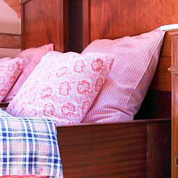 Gemuetliches Schlafzimmer im Ferienhaus in Balgoij, Rijk van Nijmegen, Gelderland mit Holzinterieur und bequemen Betten.