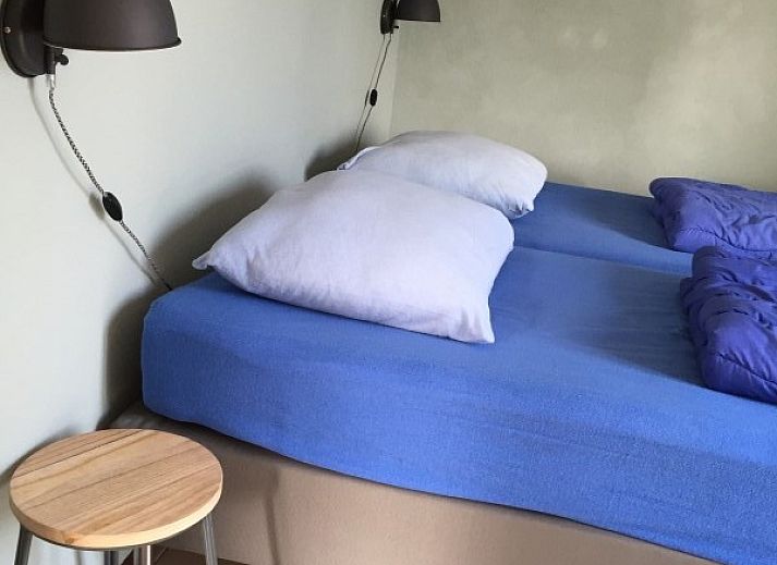 Zonnig terras met parasol bij bungalow Ons Eilandgevoel in De Cocksdorp, Texel, perfect voor ontspanning.