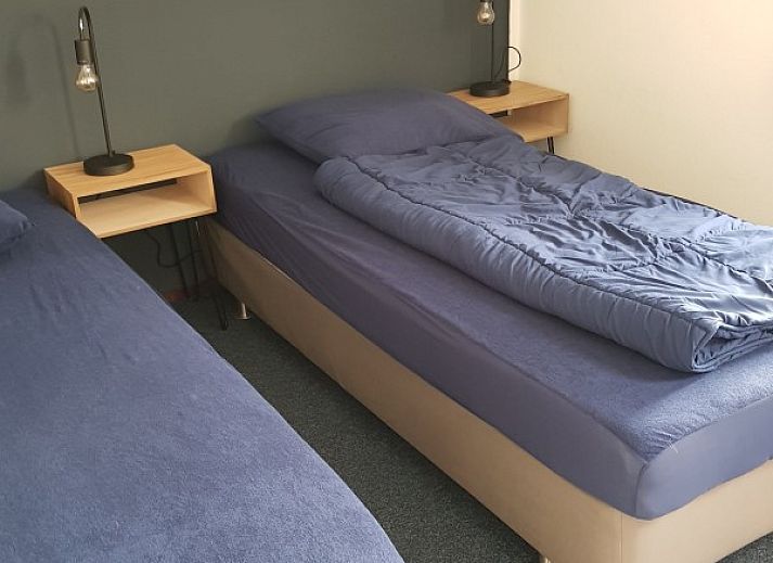 Zonnig terras met parasol bij bungalow Ons Eilandgevoel in De Cocksdorp, Texel, perfect voor ontspanning.