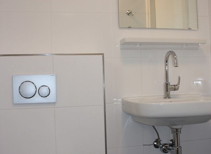 Moderne Kueche im Ferienhaus Roggeslootweg 628, De Cocksdorp, Texel mit Essecke und Blick auf die gruene Umgebung.