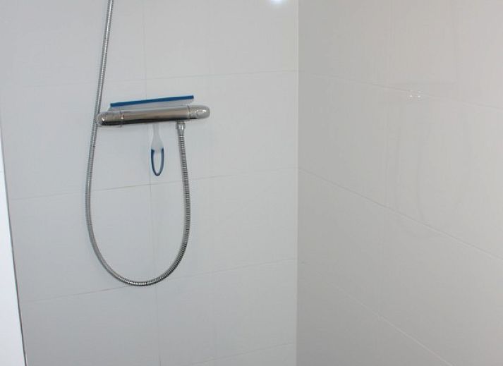 Moderne Kueche im Ferienhaus Roggeslootweg 628, De Cocksdorp, Texel mit Essecke und Blick auf die gruene Umgebung.