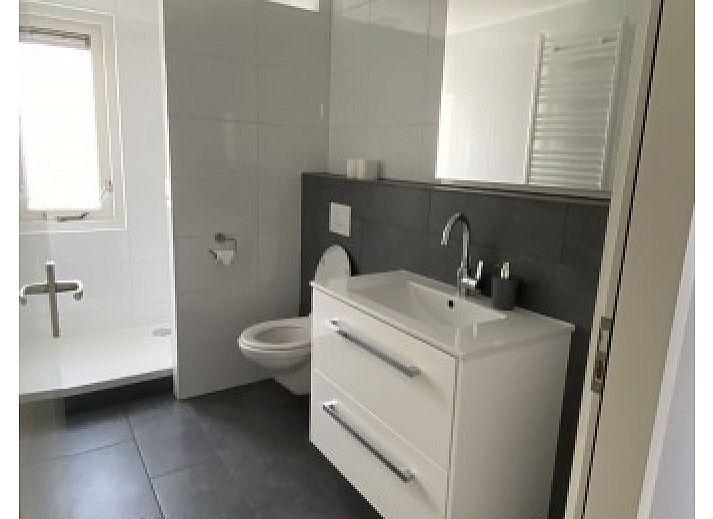 Buitenterras van Luxe 8 persoons Golf Villa Texel in De Cocksdorp met grote eettafel, ideaal voor gezellige diners in de natuur.